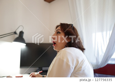 Woman working from home is having a revelation while taking notes 127756335