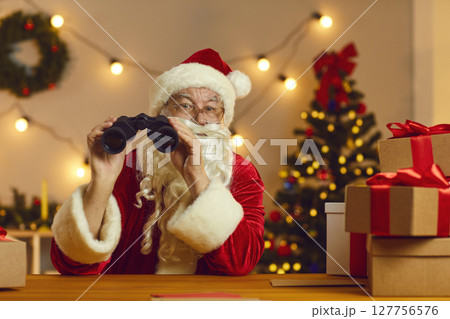Old Father Christmas with binoculars spying on who's been naughty or nice this year 127756576