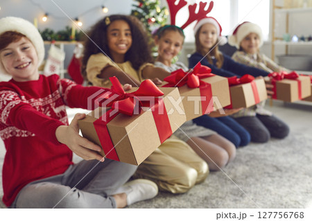 Smiling kids holding gift boxes and wishing everyone Merry Christmas and Happy New Year Smiling kids holding gift boxes and wishing everyone Merry Christmas and Happy New Year 127756768