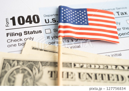 Tax Return form 1040 with USA America flag and dollar banknote, U.S. Individual Income. 127756834
