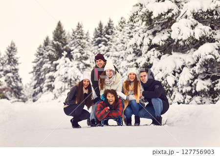 Cheerful people on sleigh in snowy woods 127756903