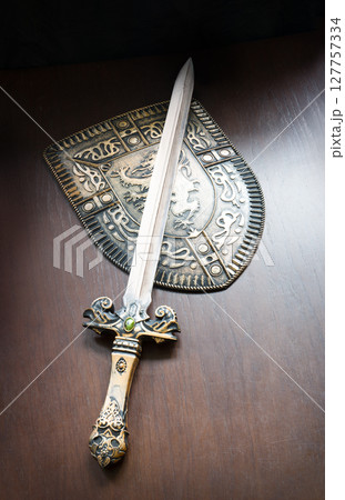 Iron shield and sword on the table Iron shield and sword on the table 127757334