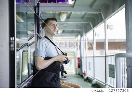 フェリーの通路でカメラを構える男性旅行者 127757808