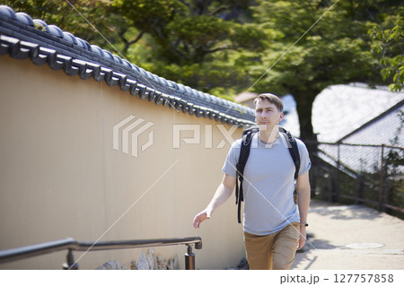 歴史的な町並みを歩く男性旅行者 127757858