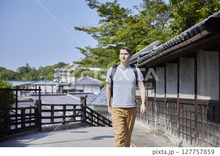 歴史的な町並みを歩く男性旅行者 127757859