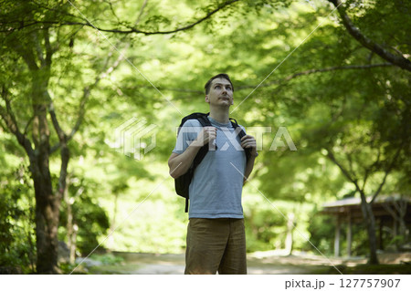 バックパックを背負い自然散策する男性 127757907