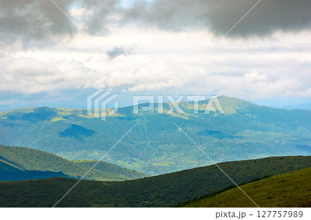 mountain landscape with green pikui peak under storm sky. beautiful summer scenery of carpathian watershed ridge. scenic view of valley in dappled light. outdoor adventure in highland of ulraine 127757989