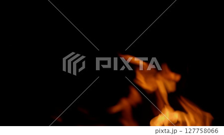 Dynamic flames dance beautifully in darkness, creating a captivating display of light and heat Dynamic flames dance beautifully in darkness, creating a captivating display of light and heat 127758066