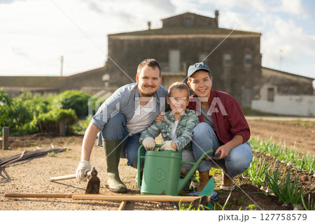 Family of farmers standing in the garden 127758579