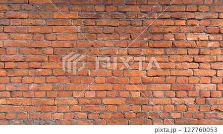 Close-up view of red brick wall with prominent texture and warm lighting. Horizontal alignment creates rhythmic pattern. Background displays muted grout. Neural network AI generated 127760053