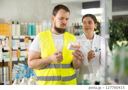 Male builder choosing pills in pharmacy Male builder choosing pills in pharmacy 127760415