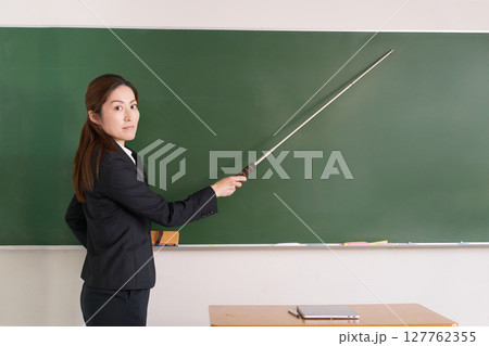 指示棒を持って視線を向ける女性教師 127762355