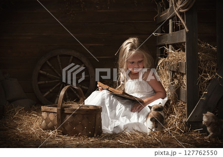 Girl with a kitten on hay Girl with a kitten on hay 127762550