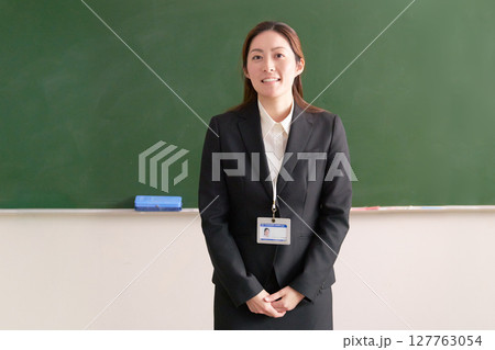 黒板の前に立って話をする女性教師 127763054