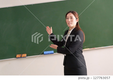 黒板の前に立つ女性教師 127763057