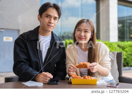 Young Asian couple eating fried chicken 127763204
