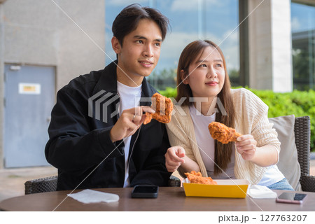 Young Asian couple eating fried chicken 127763207
