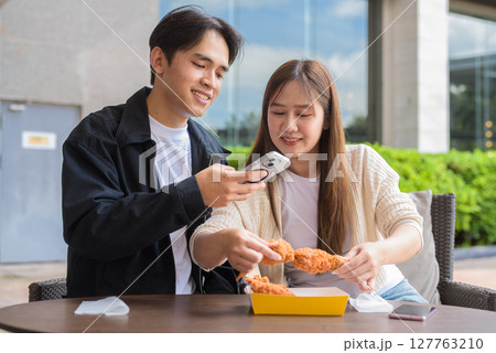 Young Asian couple eating fried chicken 127763210