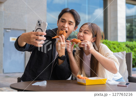 Young Asian couple eating fried chicken 127763216