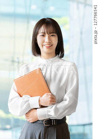 バインダーを持つ笑顔の女性・ビジネスウーマン 127766541