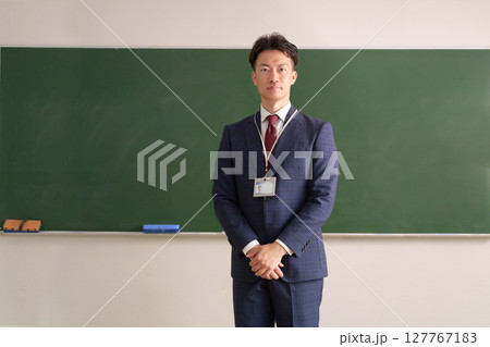 黒板の前に立つ男性教師 127767183
