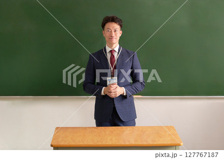 黒板の前に立つ男性教師 127767187