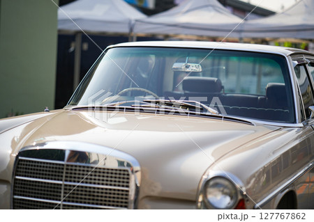 The windshield and chrome wipers of a classic car showcase the timeless allure of vintage automotive design, with their glossy finish and detailed craftsmanship sparking nostalgia for a past era. 127767862