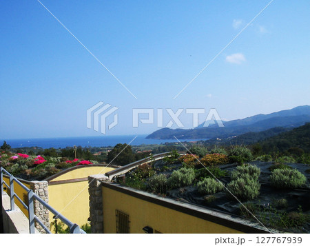 Panoramic distant view of the sea from the island of Elba, Italy, where the deep blue waters stretch like a silk blanket beneath the golden Mediterranean sun. From afar, the coastline curves Panoramic distant view of the sea from the island of Elba, Italy, where the deep blue waters stretch like a silk blanket beneath the golden Mediterranean sun. From afar, the coastline curves 127767939