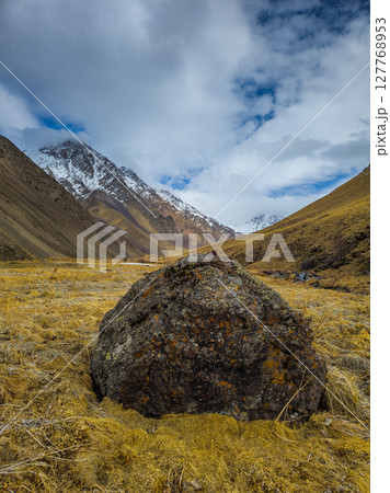 Serene mountain valley with dramatic boulder during daytime in Kyrgyzstan Serene mountain valley with dramatic boulder during daytime in Kyrgyzstan 127768953