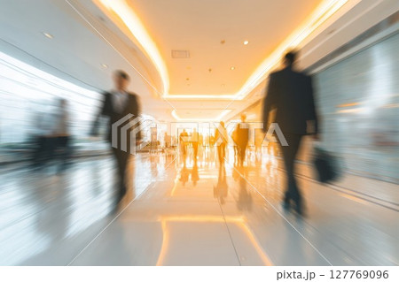 Busy office hallway with blurred people moving. Bright lights create dynamic urban scene. Ideal for business or city life themes. 127769096