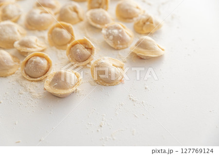 Raw homemade dumplings dusted with flour. 127769124