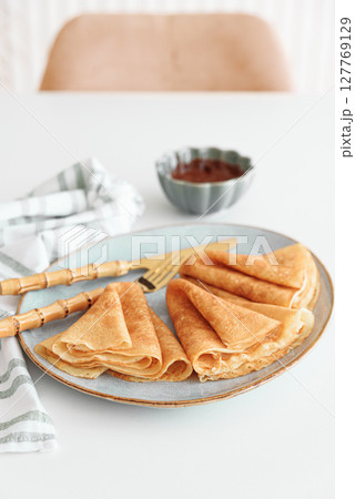 Crepes with chocolate cream and coffee on white wooden table. Pancake day, Maslenitsa Crepes with chocolate cream and coffee on white wooden table. Pancake day, Maslenitsa 127769129
