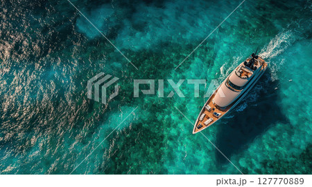 Luxurious yacht cruising through clear blue ocean waters from aerial perspective 127770889