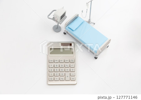電卓とミニチュアの医療ベッド、心電図モニター、点滴などの医療用品 医療費や保険のイメージ 電卓とミニチュアの医療ベッド、心電図モニター、点滴などの医療用品 医療費や保険のイメージ 127771146