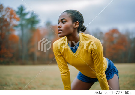 A woman in a yellow shirt and blue shorts is looking at something A woman in a yellow shirt and blue shorts is looking at something 127771606