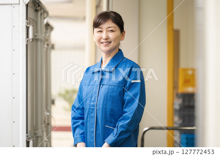 倉庫で働く作業服を着た50代の女性 127772453