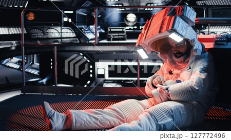Astronaut pressing wrist display to send SOS signal after onboard incident triggers critical alert. Injured space station crew member attempts to contact ground control during emergency Astronaut pressing wrist display to send SOS signal after onboard incident triggers critical alert. Injured space station crew member attempts to contact ground control during emergency 127772496
