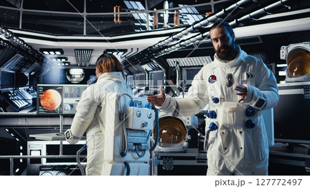 Astronaut waves hand, communicating with command center during videocall to share recent orbit discoveries. Cosmonaut salutes Earth team, provides scientific findings from spacecraft Astronaut waves hand, communicating with command center during videocall to share recent orbit discoveries. Cosmonaut salutes Earth team, provides scientific findings from spacecraft 127772497