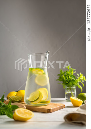 A glass jug with lemonade with lemons, limes and fresh mint, summer drink 127772672