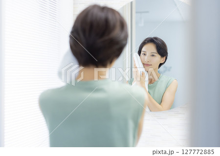 洗顔してタオルで顔を拭く女性 洗顔してタオルで顔を拭く女性 127772885