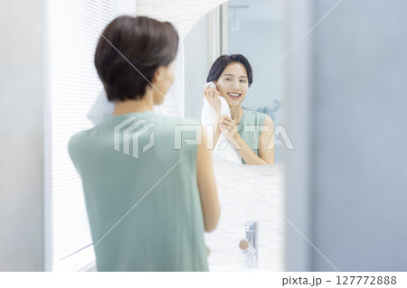 洗顔してタオルで顔を拭く女性 洗顔してタオルで顔を拭く女性 127772888