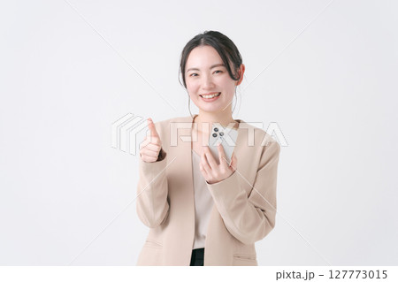 スマホを持つスーツの女性 127773015