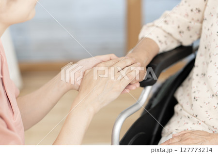車椅子のシニア女性と話をする女性介護士 ボディパーツ 握手 手を握る コミニュケーション 車椅子のシニア女性と話をする女性介護士 ボディパーツ 握手 手を握る コミニュケーション 127773214
