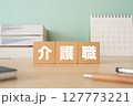 介護職と書かれたブロックが置かれたデスク 127773221