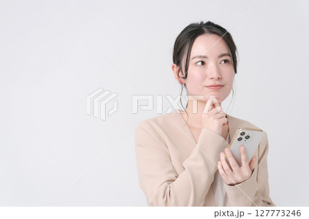 スマホを持つスーツの女性 127773246