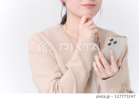 スマホを持つスーツの女性 127773247