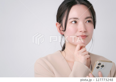 スマホを持つスーツの女性 127773248