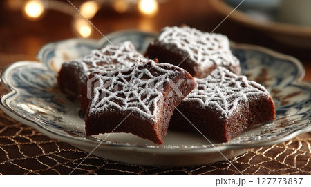 Star-Shaped Chocolate Cookies with Powdered Sugar on a Decorative Plate Star-Shaped Chocolate Cookies with Powdered Sugar on a Decorative Plate 127773837