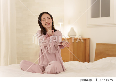 夜ベッドでストレッチする女性 夜ベッドでストレッチする女性 127774579
