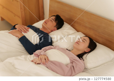 ダブルベッドで一緒に寝る夫婦 127774580